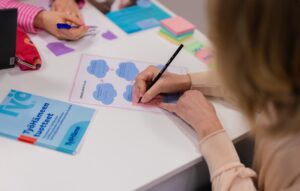 Henkilö täyttää pöydän äärellä työnhakuun liittyvää lomaketta